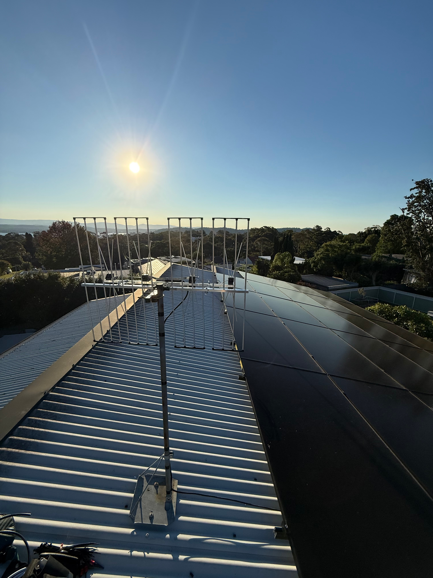 Antenna technician installing a TV antenna on a rooftop